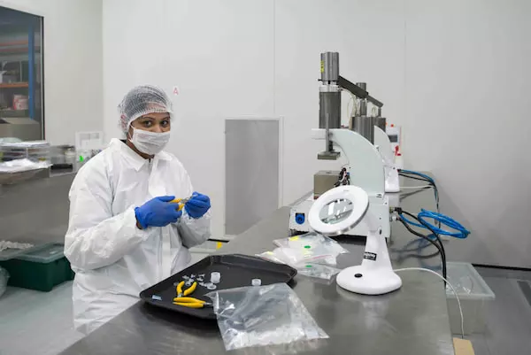 Woman wearing gloves and mas packaging the silicons