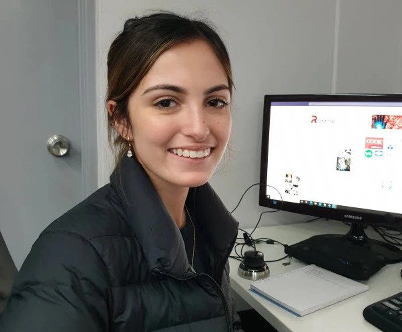 A woman smiling while doing work on the computer